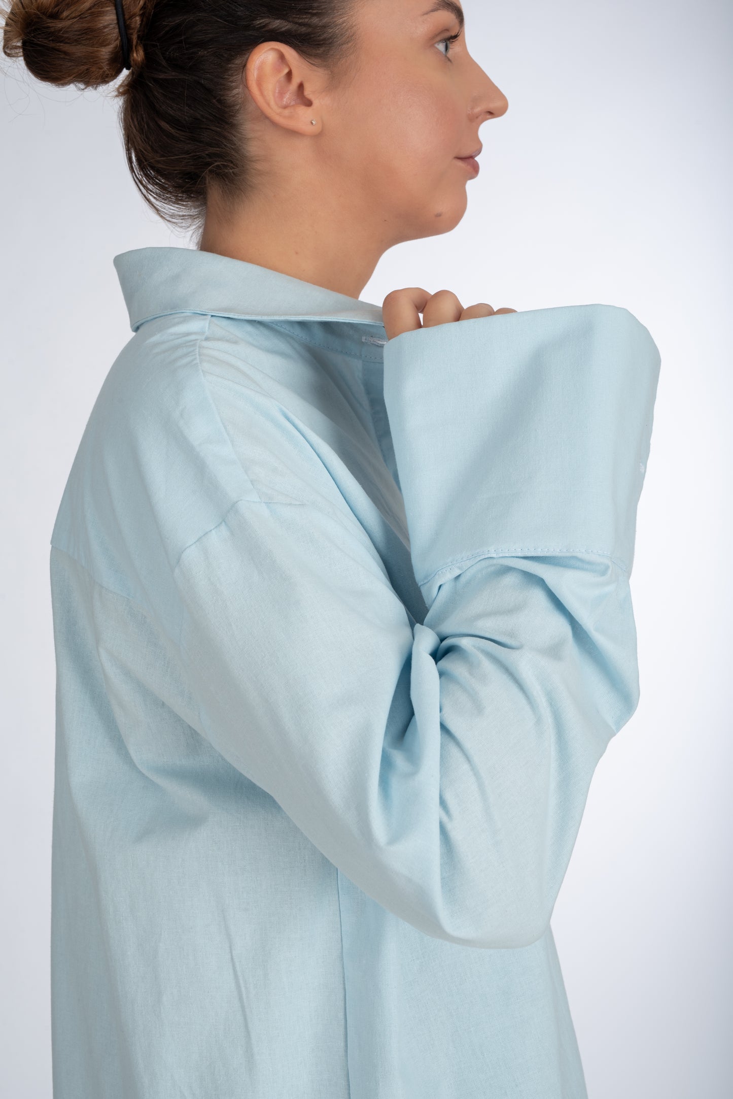Side view of a baby blue women's shirt, emphasizing the size and fit of the sleeve cuff with precision tailoring and reinforced structure.